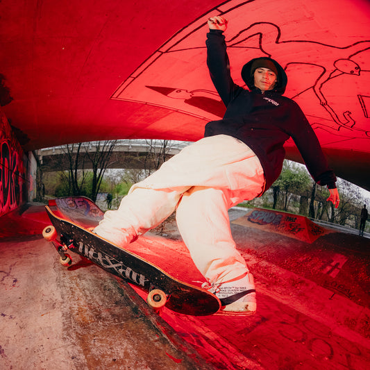 Black skateboard deck with Maxolut logo in action.