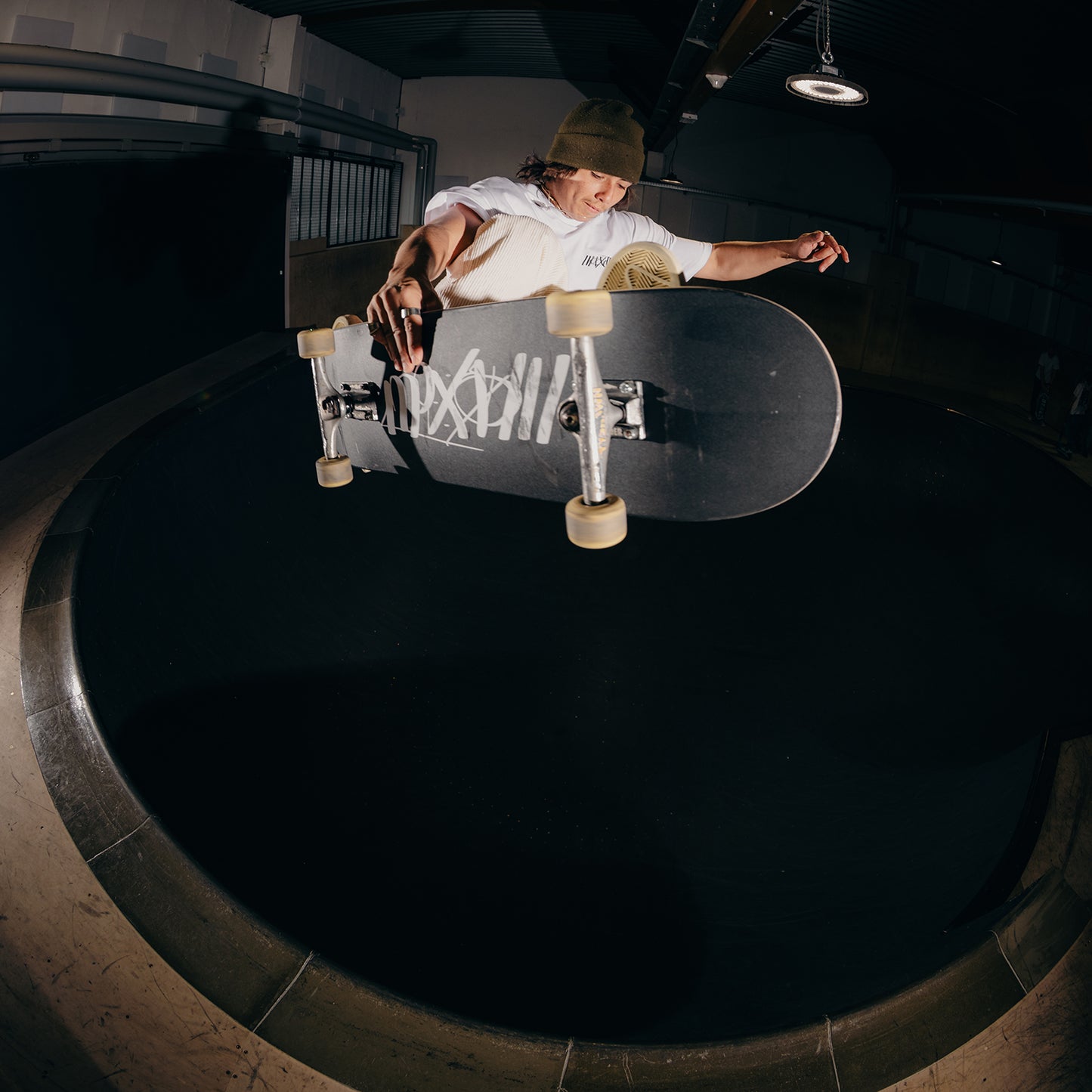 Black skateboard deck with Maxolut logo rolling.
